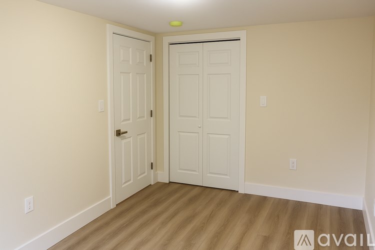 A room with two doors and wooden flooring.