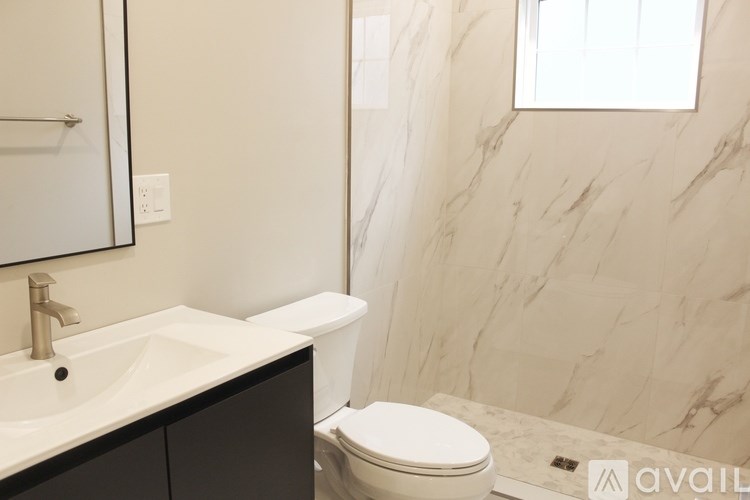 A bathroom with a marble wall and a toilet.