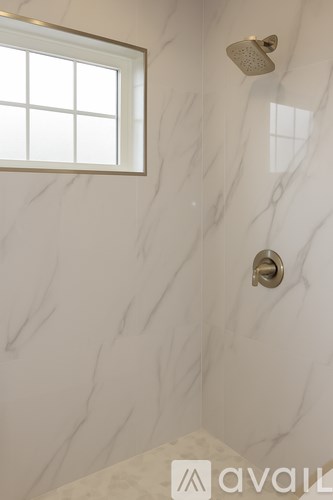 A bathroom with a marble wall and a window.