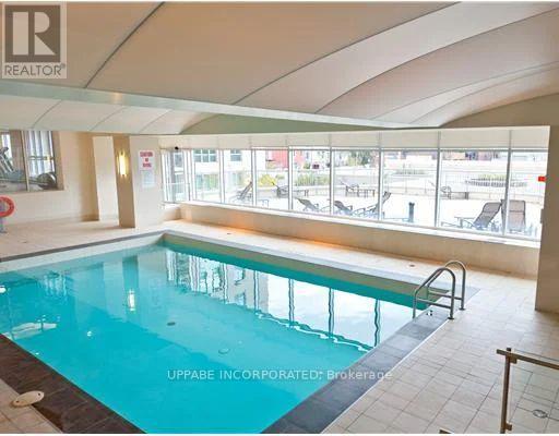 A swimming pool inside a building with a sign that says "UPPABE INCORPORATED Brokerage".