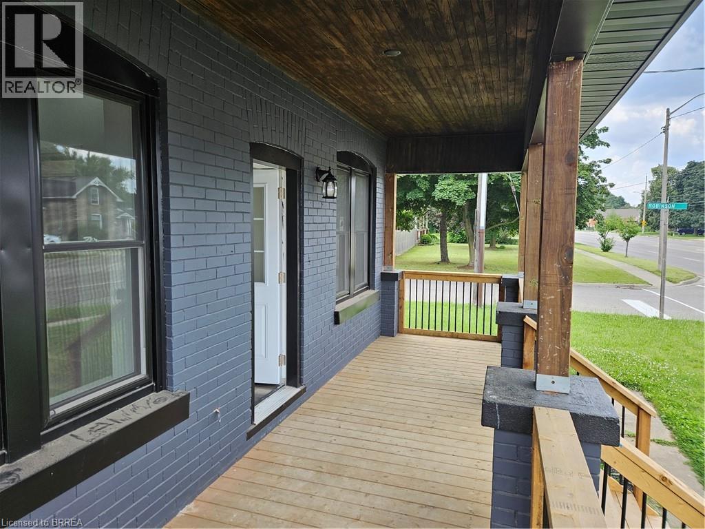A porch with a wooden floor and a railing.