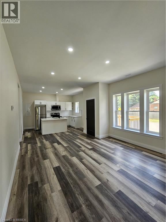 A spacious room with a kitchen area and a large window.