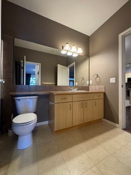A bathroom with a toilet, sink, and mirror.