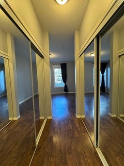 A long hallway with wood floors and white walls.