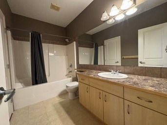 A bathroom with a toilet, sink, and shower.