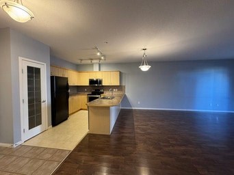A kitchen with a black fridge and a black oven.