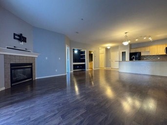 A spacious living room with a fireplace and a television mounted above it.