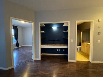 A room with a dark blue wall and a wooden floor.