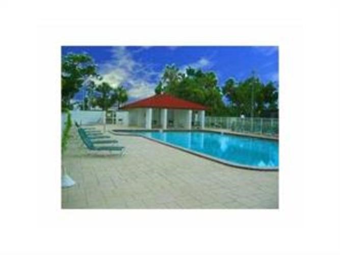 A pool with a red roof and a pavement.