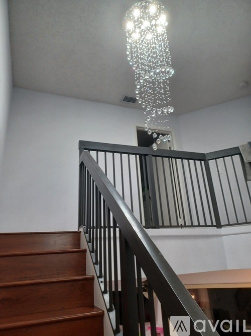 A staircase with a chandelier hanging from the ceiling.
