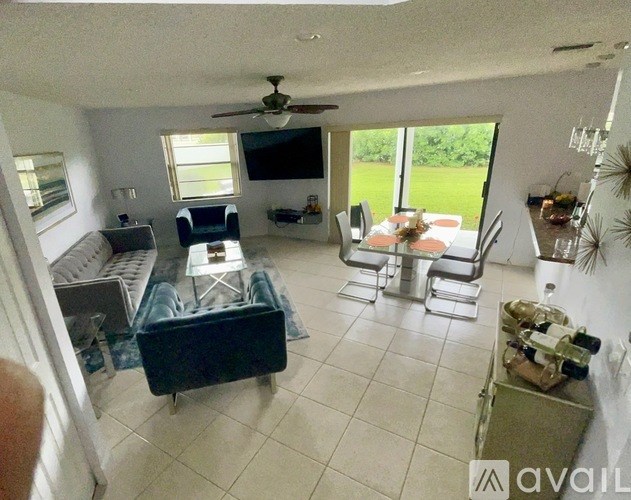 A living room with a television, a couch, and a dining table.