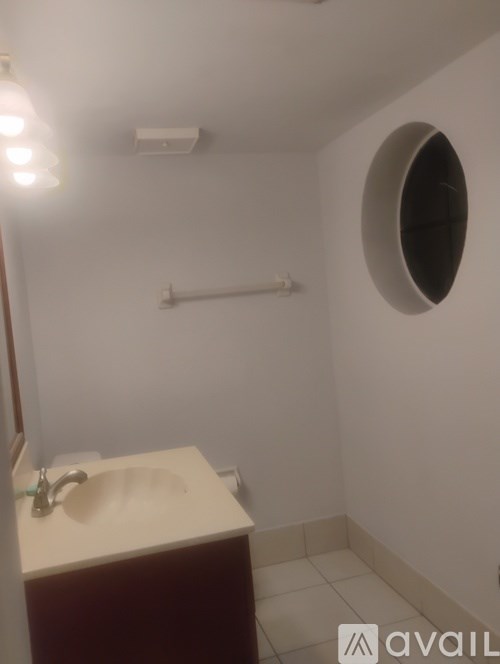 A bathroom with a round hole in the wall.
