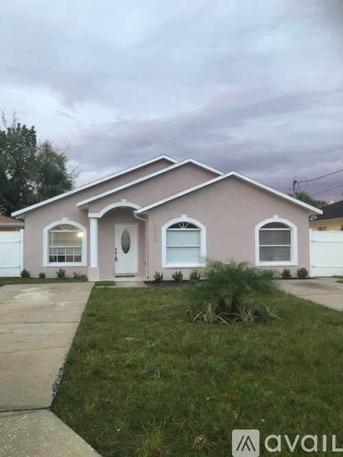 A house with a pink facade and white trim is shown.