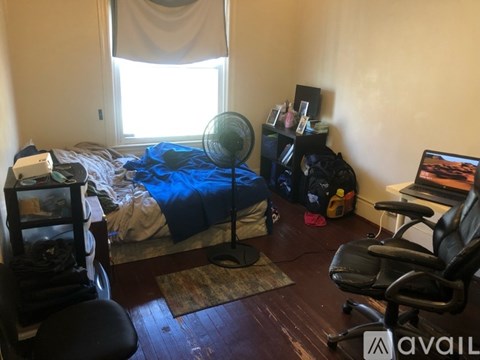 A room with a bed, a desk, and a chair.