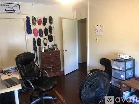 A room with a black chair and a sign that says "sidewalk closed ahead".