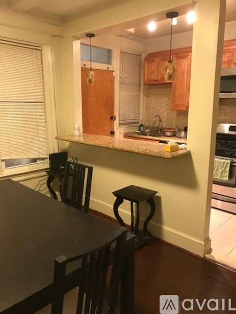 A kitchen with a table and chairs.