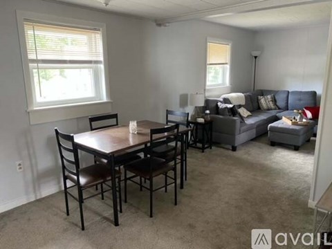 A living room with a dining table and chairs.