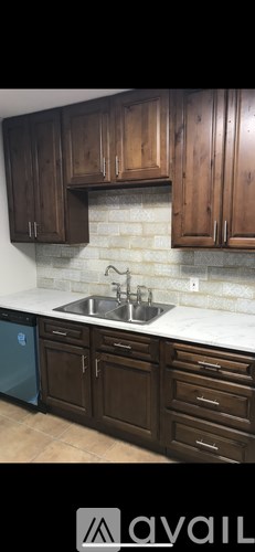 Brown wooden cabinets above a marble countertop.