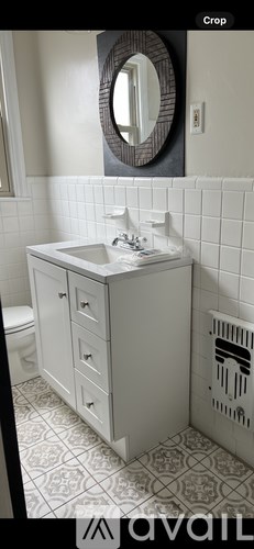 A bathroom with a white sink and a mirror above it.
