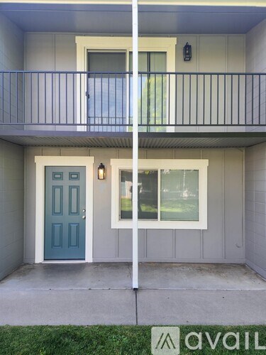 A balcony with a blue door and a window.