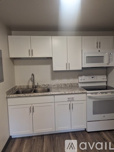 A kitchen with white cabinets and a granite countertop.