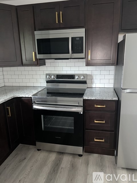 A kitchen with dark brown cabinets and a white refrigerator.