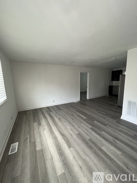 A room with wooden flooring and white walls.