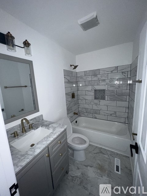 A bathroom with a marble countertop and a walk-in shower.