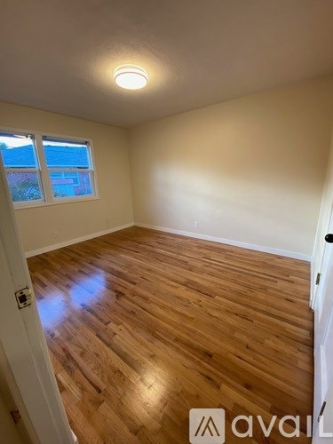 A room with wooden flooring and a window.
