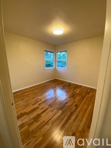 A room with wooden flooring and a window.