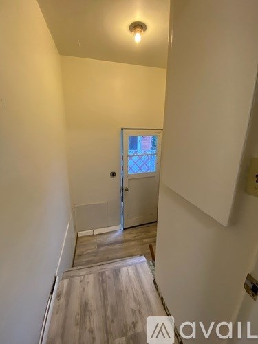 A hallway with a door leading to a balcony.