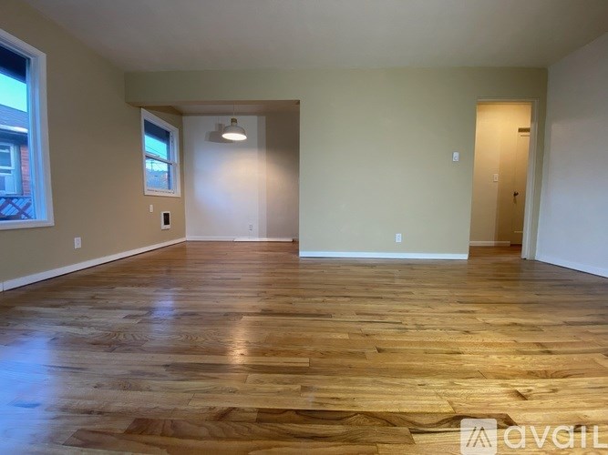 Empty room with wooden flooring and a window.