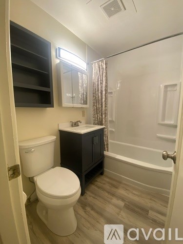 A bathroom with a toilet, sink, and bathtub.
