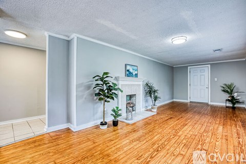 A living room with a fireplace and a painting on the wall.