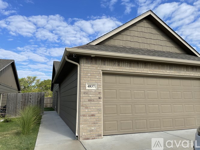 A house with a garage door and number 4837 on it.