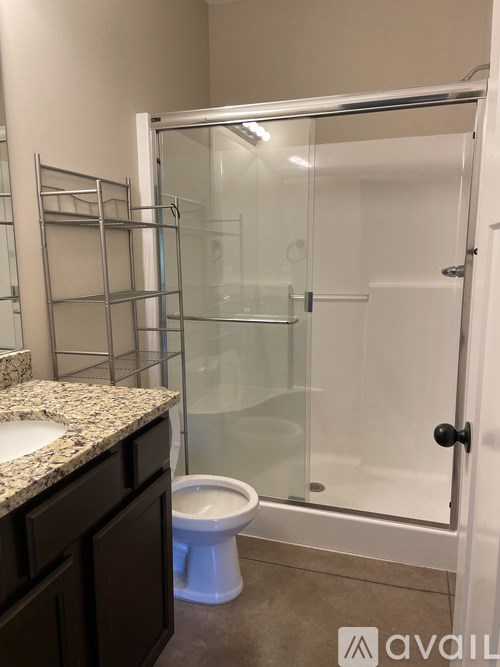 A bathroom with a toilet, sink, and shower.