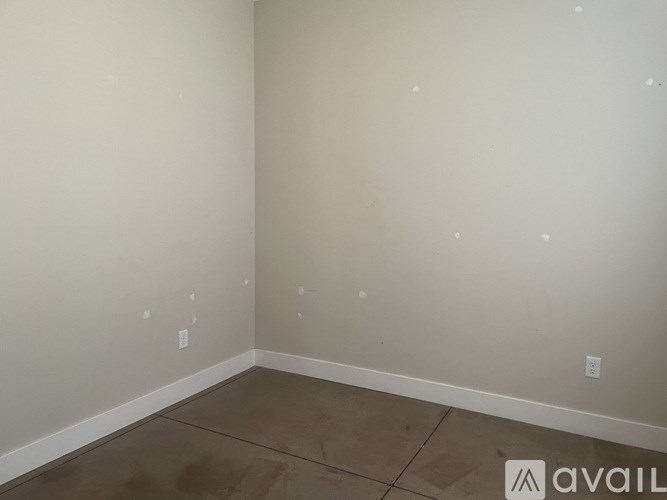 A room with a brown floor and white walls.