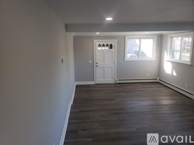 A room with wooden flooring and a white door.