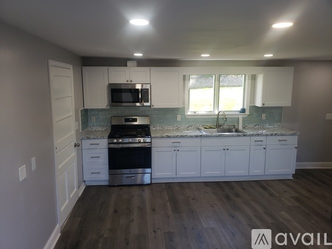 A kitchen with white cabinets and a marble countertop.
