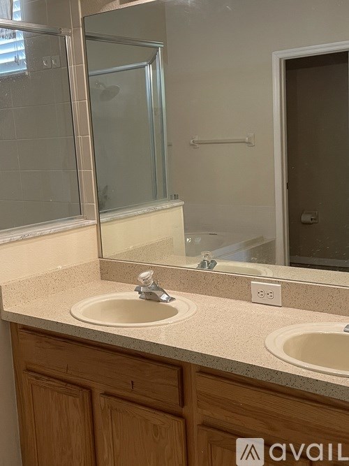 A bathroom with two sinks and a large mirror.