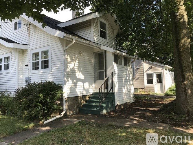A house with a white exterior and a green staircase.