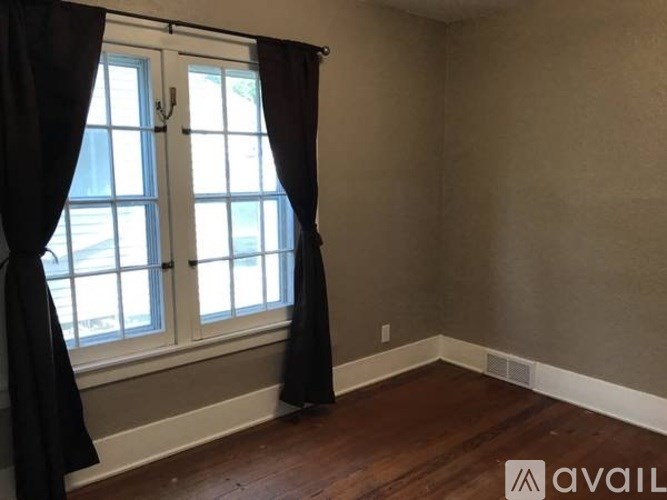 A room with a window and curtains.