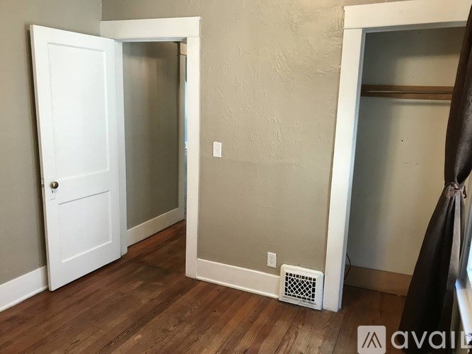 A room with a white door and a wall-mounted air vent.