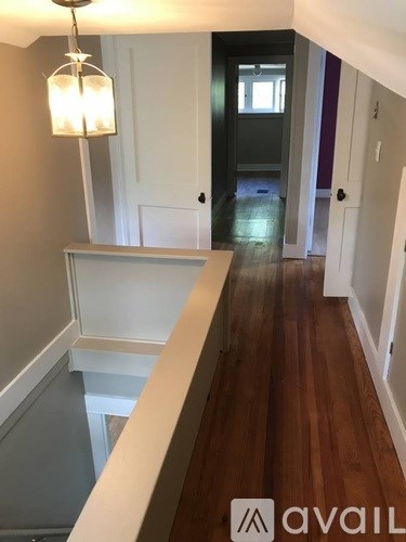 A hallway with a light on the left and a door on the right.