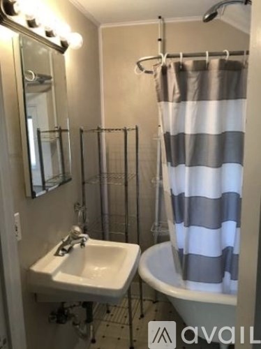 A bathroom with a white sink and a striped shower curtain.