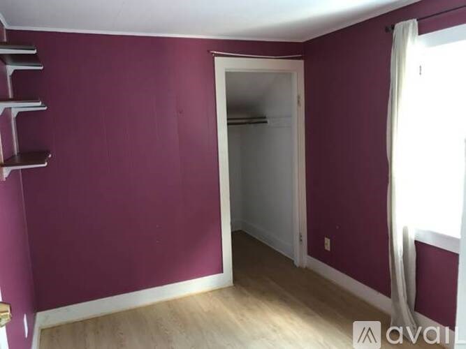 A room with purple walls and a white door.