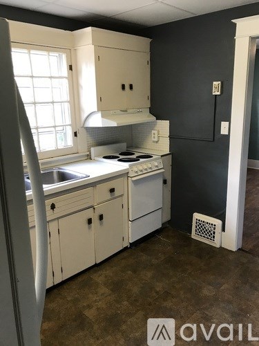 A kitchen with white cabinets and a stove top oven.