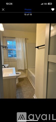 A bathroom with a toilet, sink, and shower.