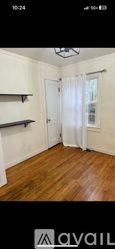 A room with wooden flooring and a white door.