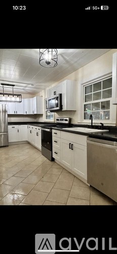 A kitchen with white cabinets and a black countertop.